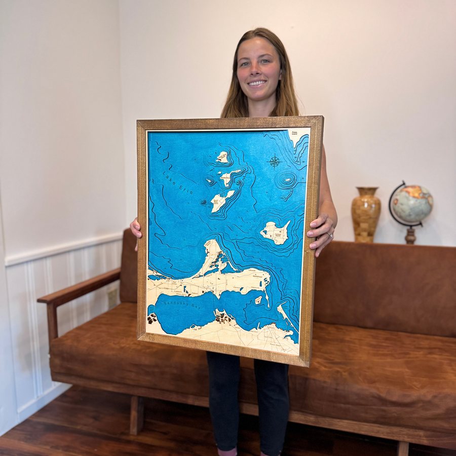A happy customer holding her finished custom Lake Erie wood map